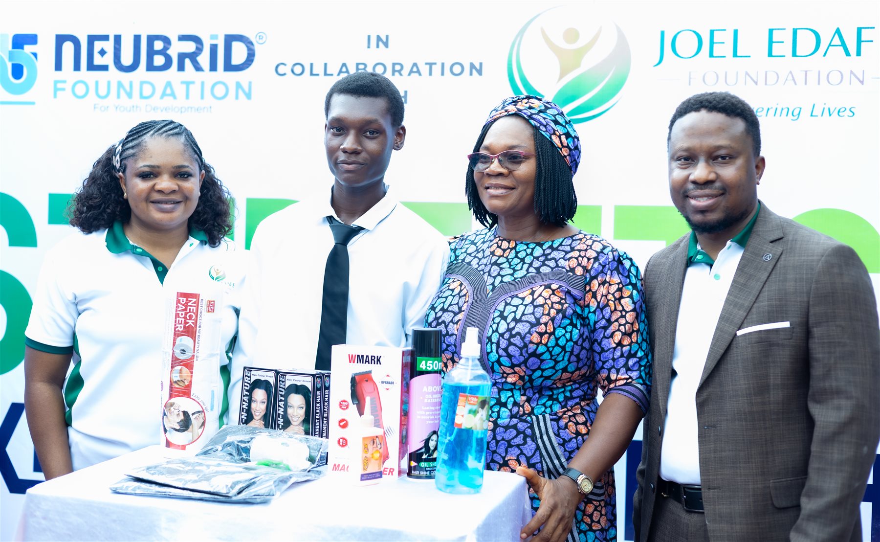 A participant and foundation representatives with barbering equipment